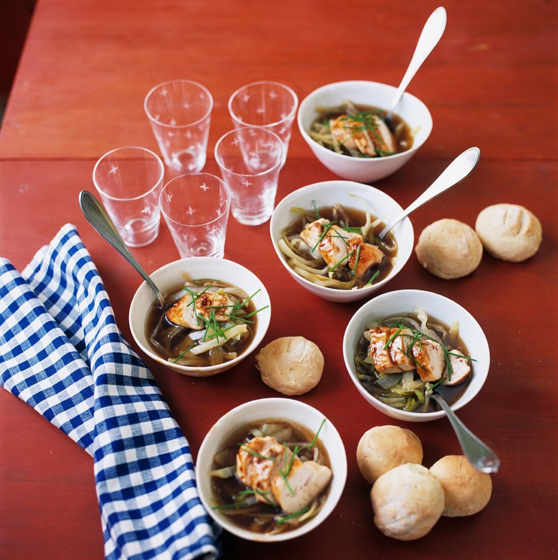 Suppe mit Nudeln & Hühnerfleisch in Schälchen dazu Brötchen