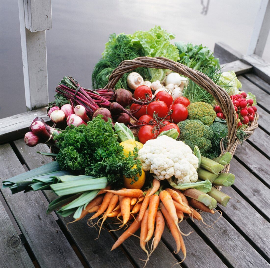 Assorted types of vegetables in a basket on a landing stage