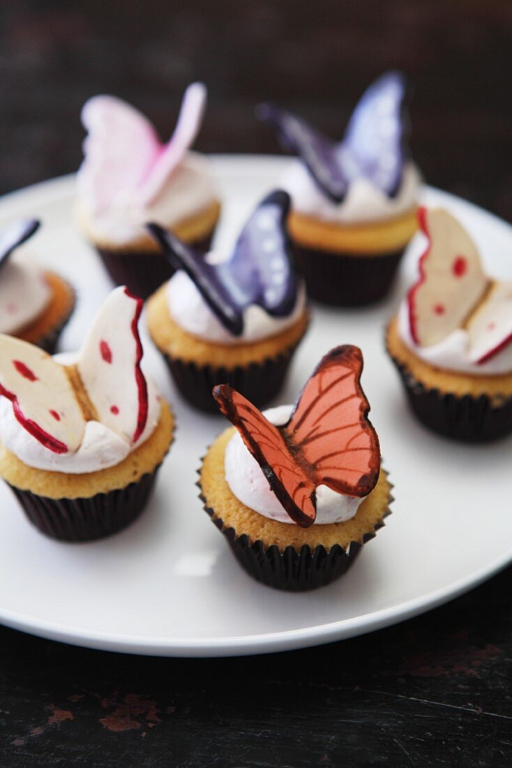 Vanilla cupcakes with cream icing and chocolate butterflies