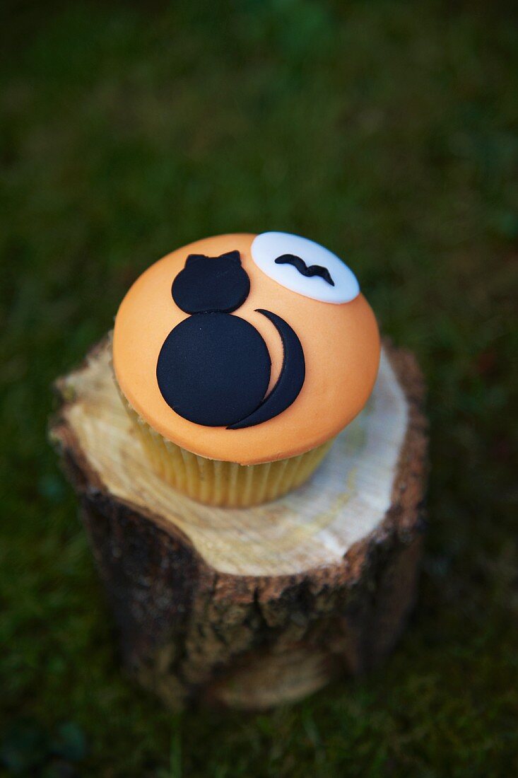 Cupcake decorated with a black cat for Halloween