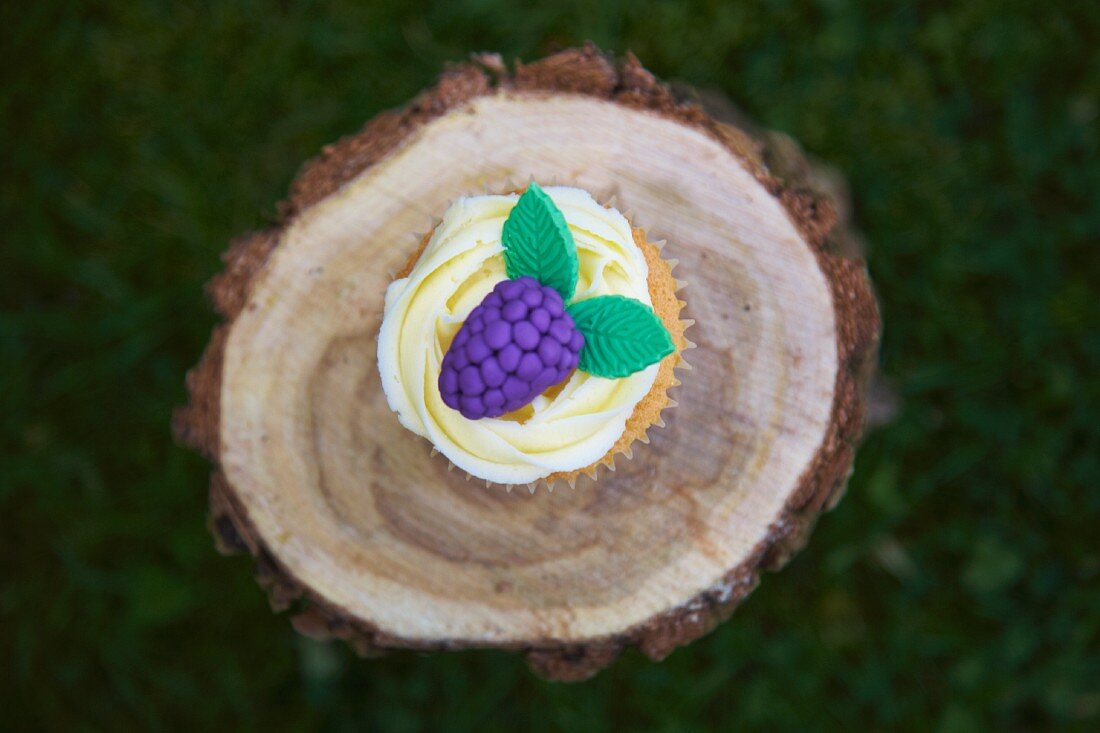 Brombeer-Cupcake auf einem Baumstamm