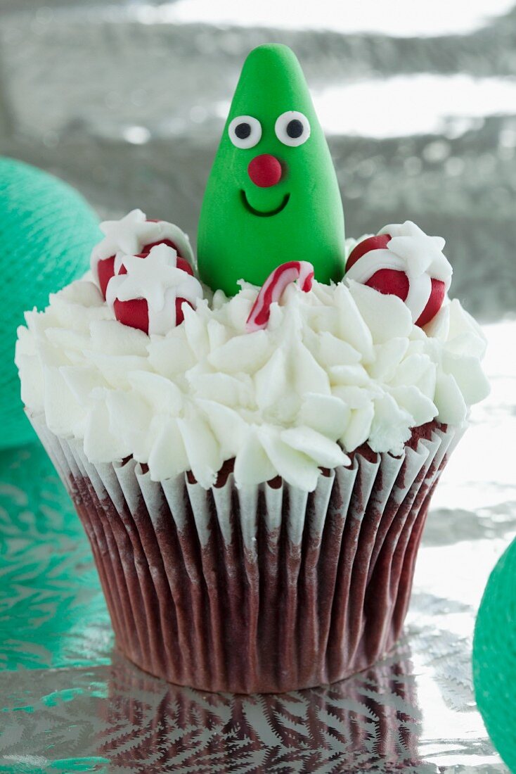 Red Velvet cupcake with cream cheese frosting and edible Christmas-themed decorations