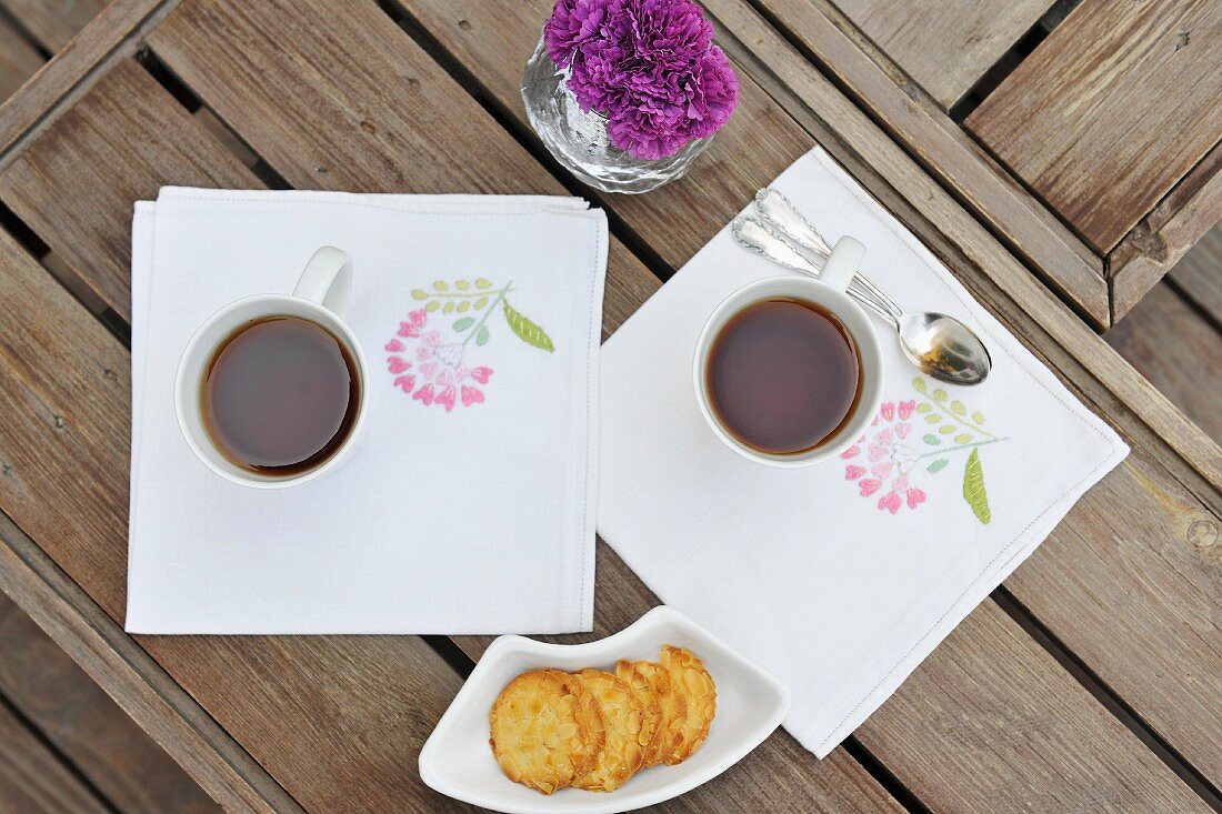 Biscuits and two cups of tea on a table in the garden