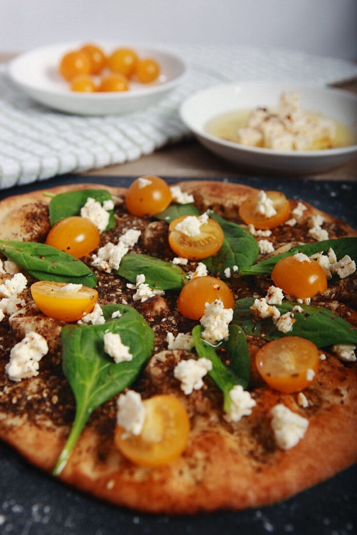 Pizza mit Spinat, Tomaten, Feta und Zatar (Gewürzmischung aus Nordafrika)