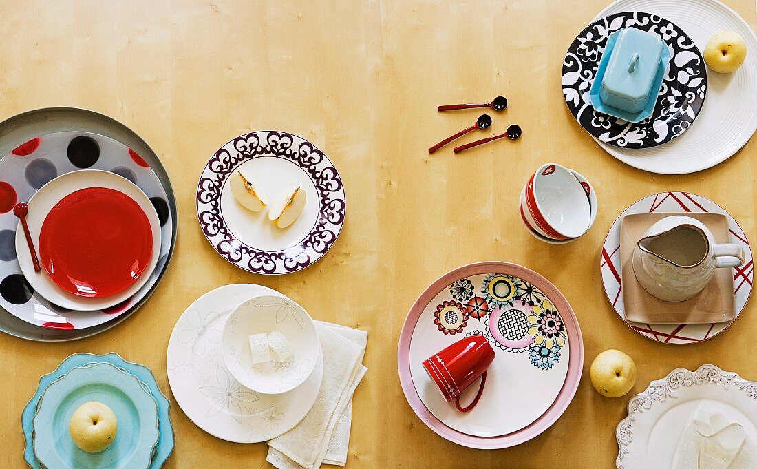 Assorted plates and cups with varying patterns and styles