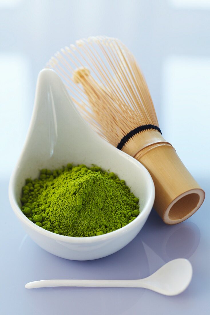 Matcha in a bowl with a bamboo whisk