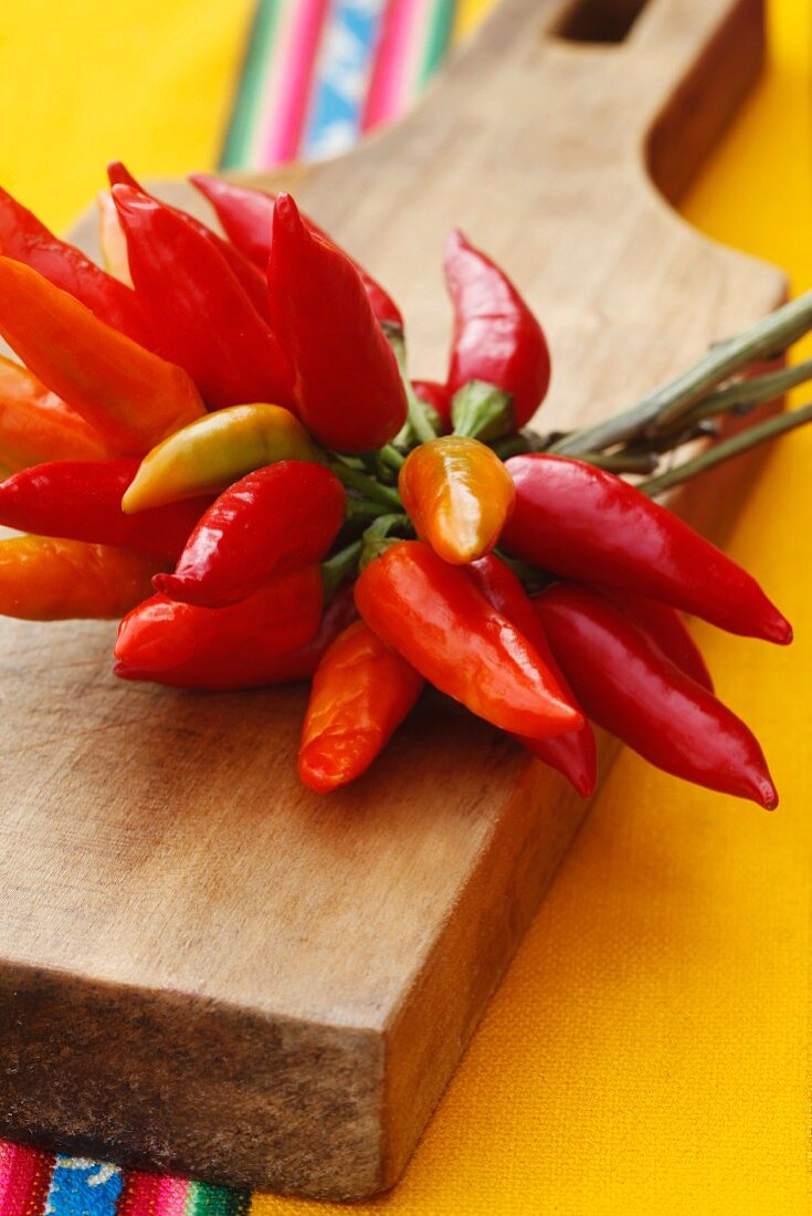 A bunch of chillies on a wooden board