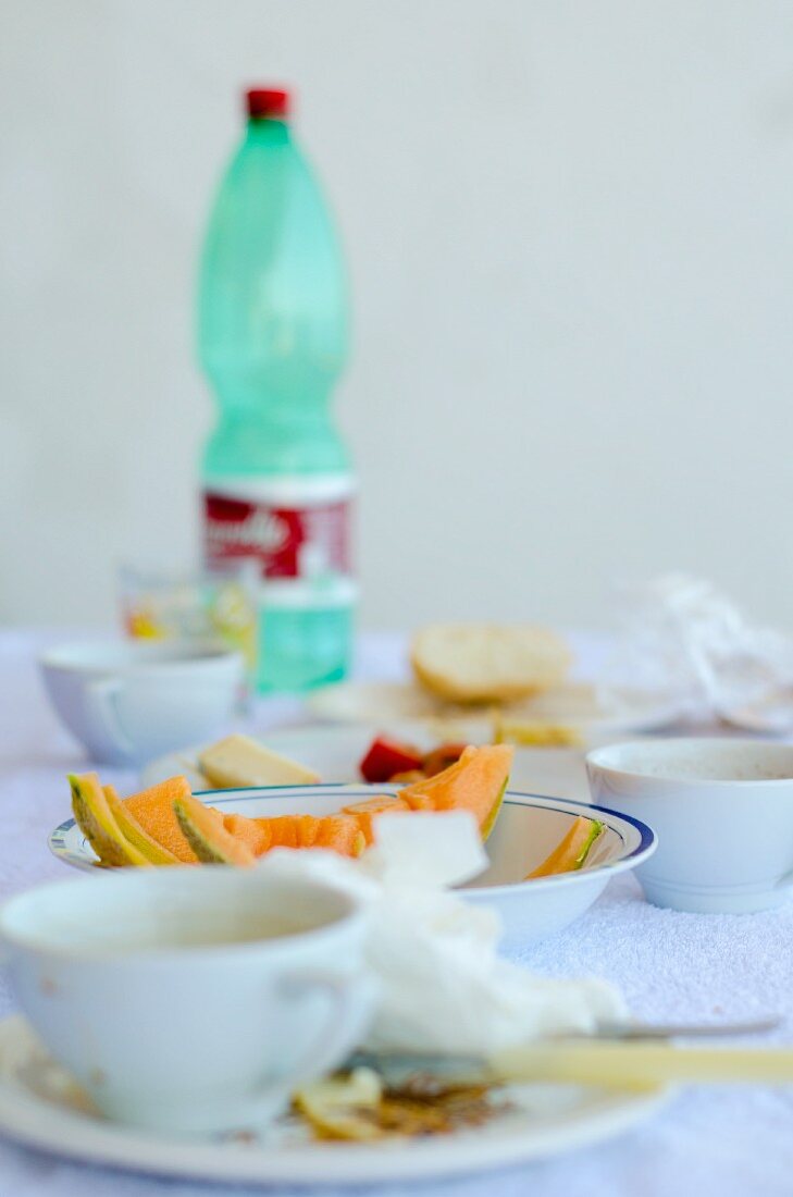Reste von einem Frühstück mit Melone und Wasserflasche