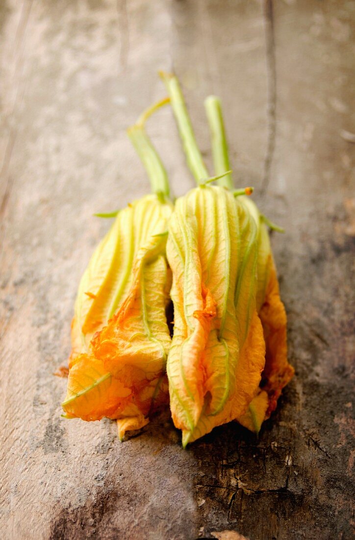 Zucchiniblüten auf altem Schneidebrett