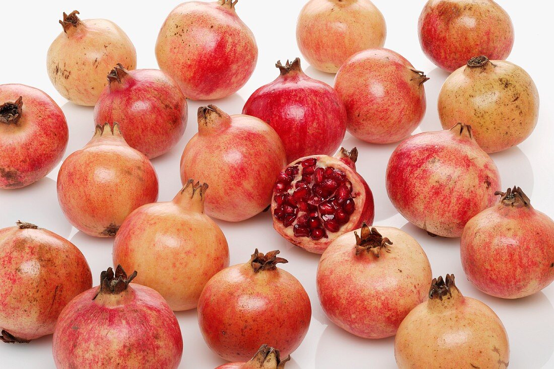 Lots of pomegranates, one halved