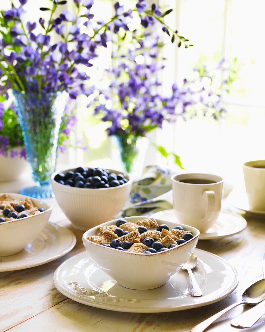 Frühstückstisch mit Heidelbeermüsli und Kaffee