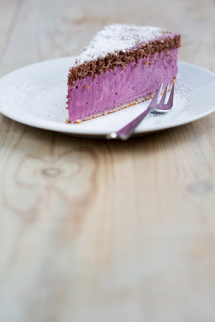 A slice of elderberry torte with icing sugar