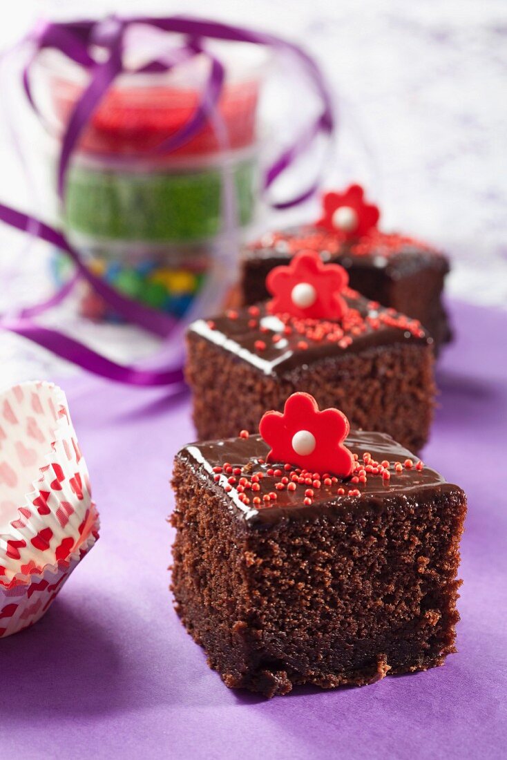 Schokoladenkuchenstücke mit Zuckerblüten verziert