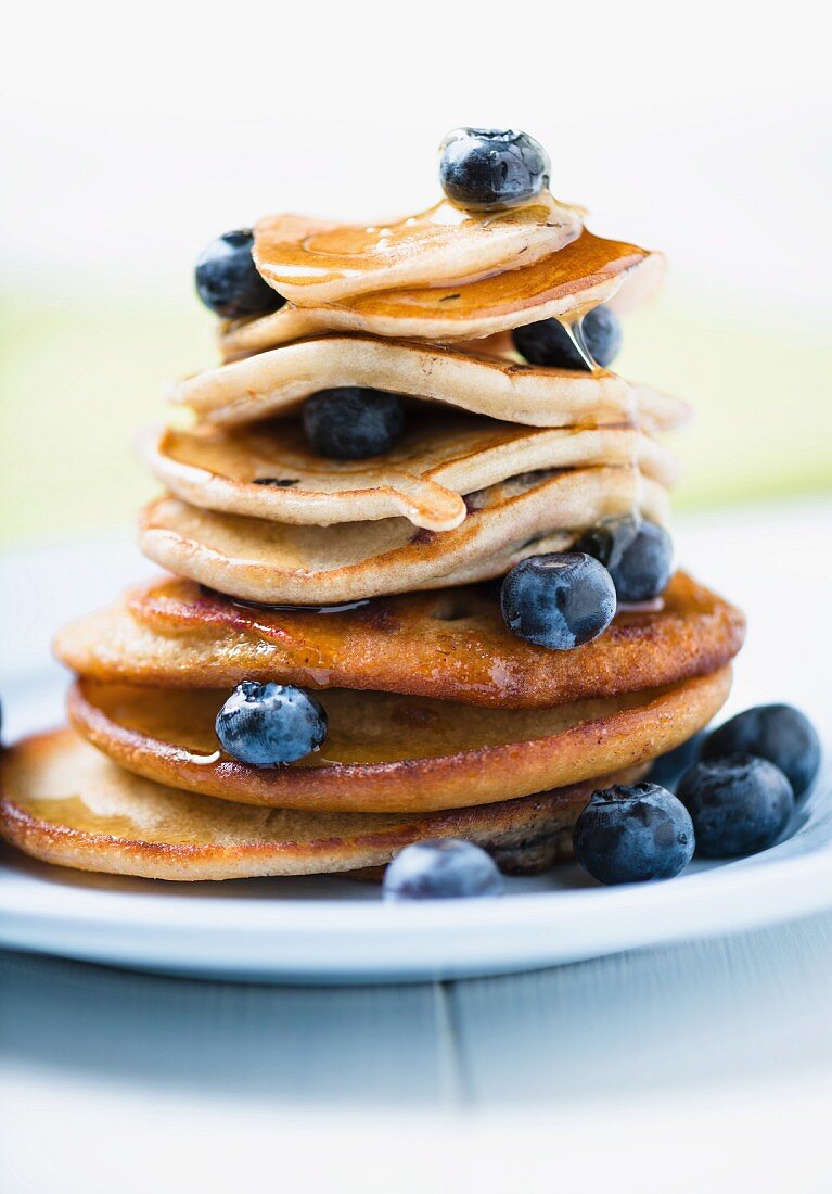 A Stack of Pancakes with Fresh Blueberries and a Syrup