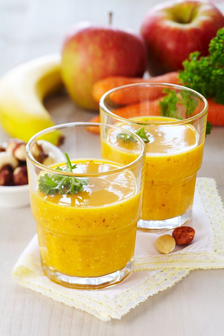 A smoothie made from bananas, carrots, apples, nuts and raisins