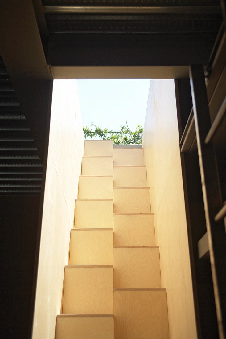 View from below up narrow light well with masonry samba staircase