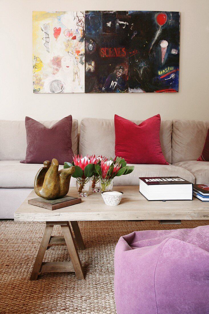 Modernes Gemälde in Wohnzimmer mit Textilien aus Naturmaterialien und einfachem Holzcouchtisch