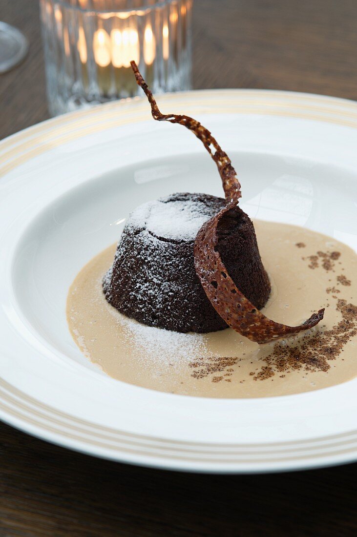 Schokoladenpudding mit Puderzucker in Kaffeesauce