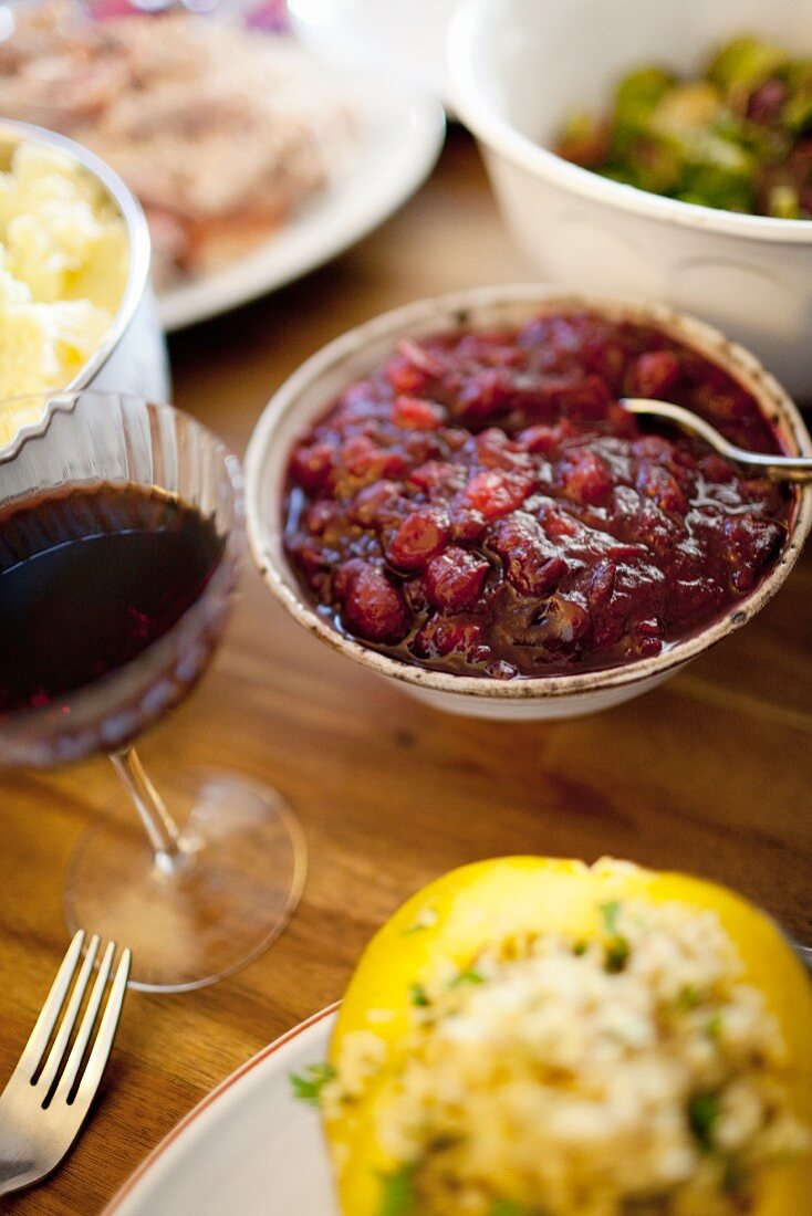 Homemade cranberry sauce on a table surrounded by other traditional Thanksgiving side dishes