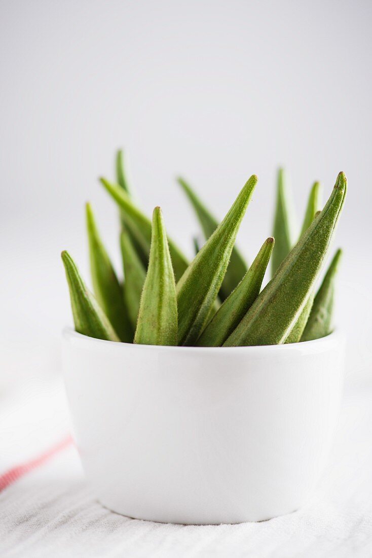 Several okra pods in a bowl
