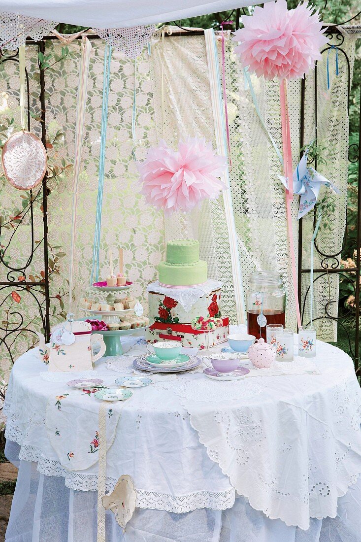 Nostalgische Kinderparty im Garten mit Tee, Kuchen und Gebäck