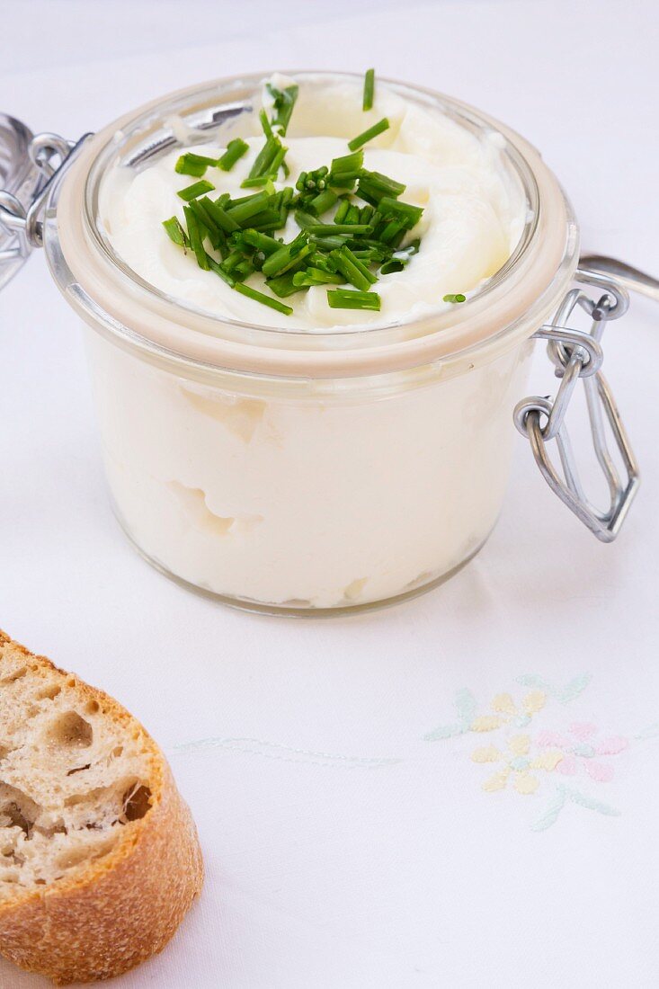 Quark with chives in a clip-top jar, and a chunk of baguette