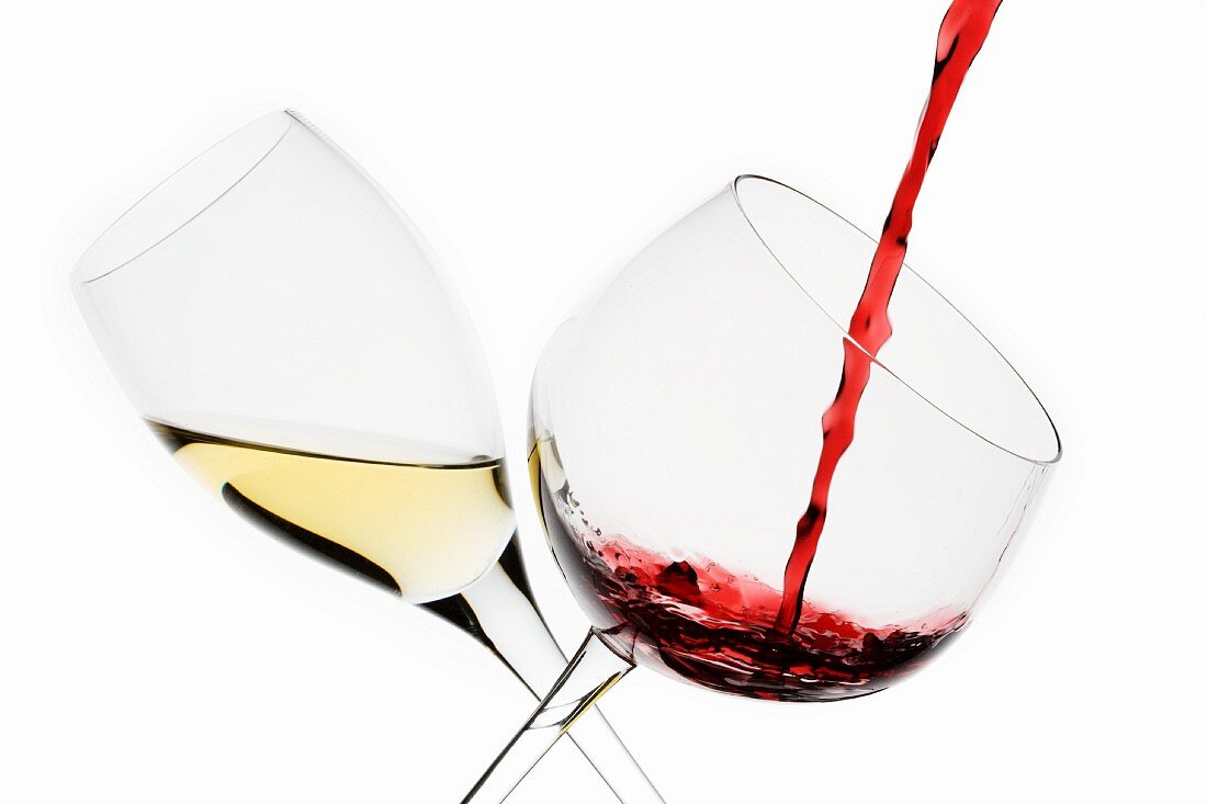 A Glass of White Wine and a Glass of Red Wine being Poured