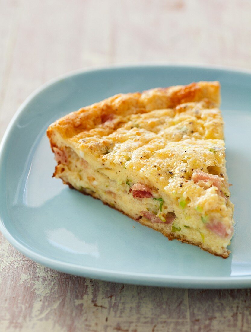 Ein Stück Schinken-Käse-Quiche auf Teller