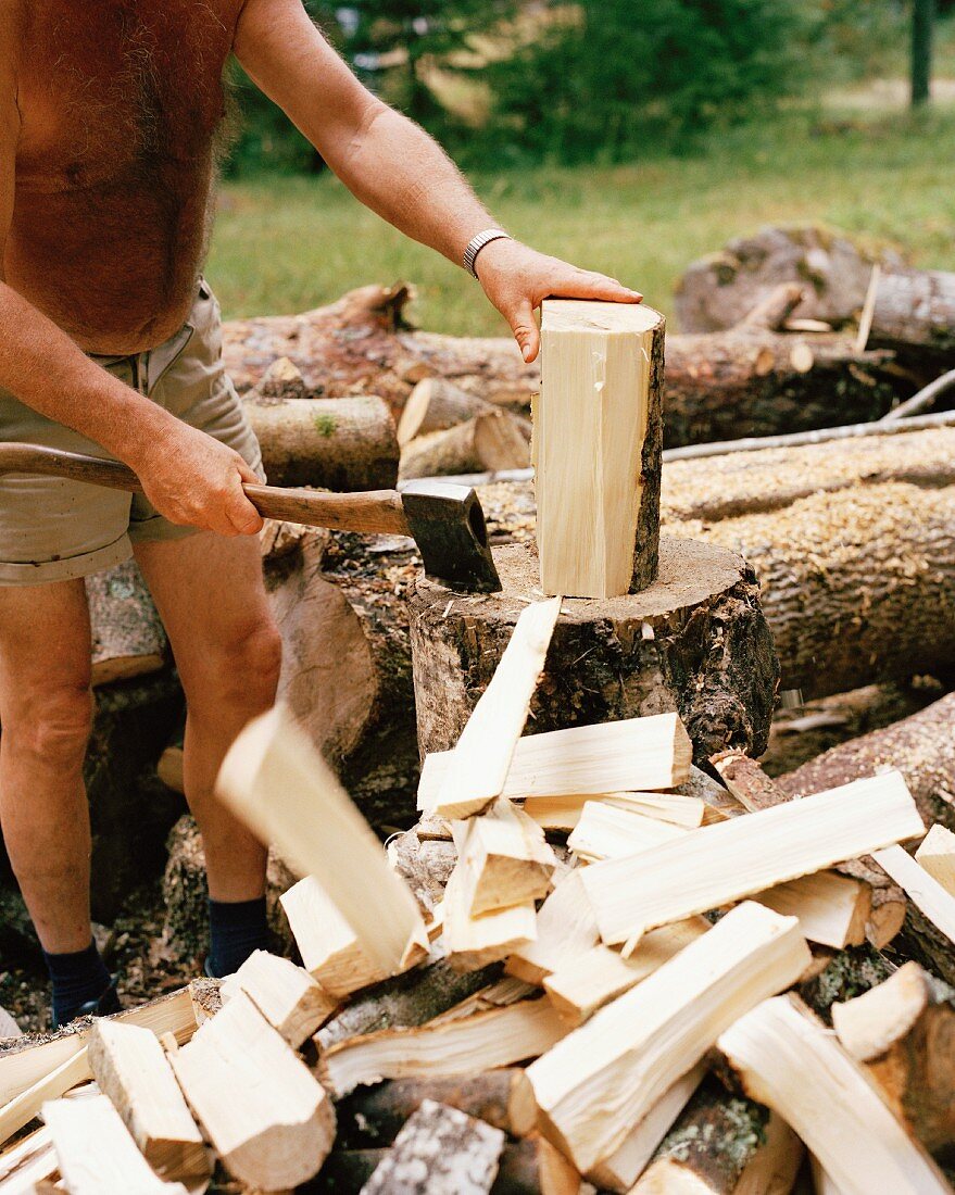 Holzhackender Mann in Shorts