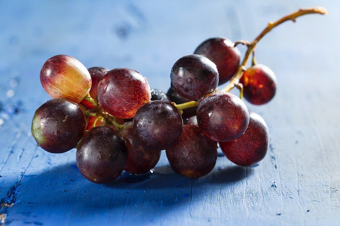 Rote Weintrauben auf blauem Holzbrett