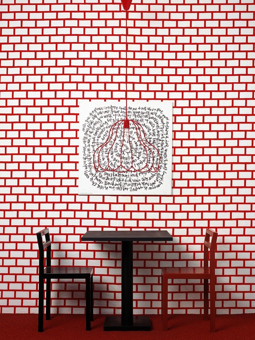 Table and chairs against red and white patterned wall