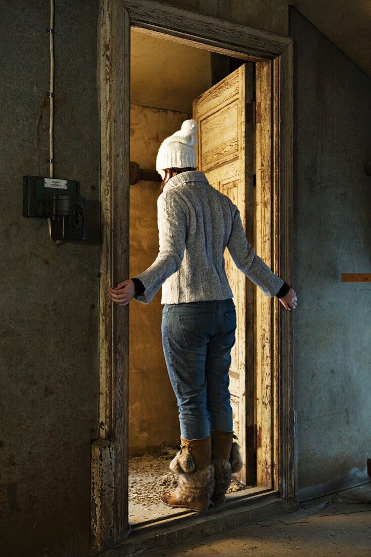 Woman in winter clothing standing in doorway