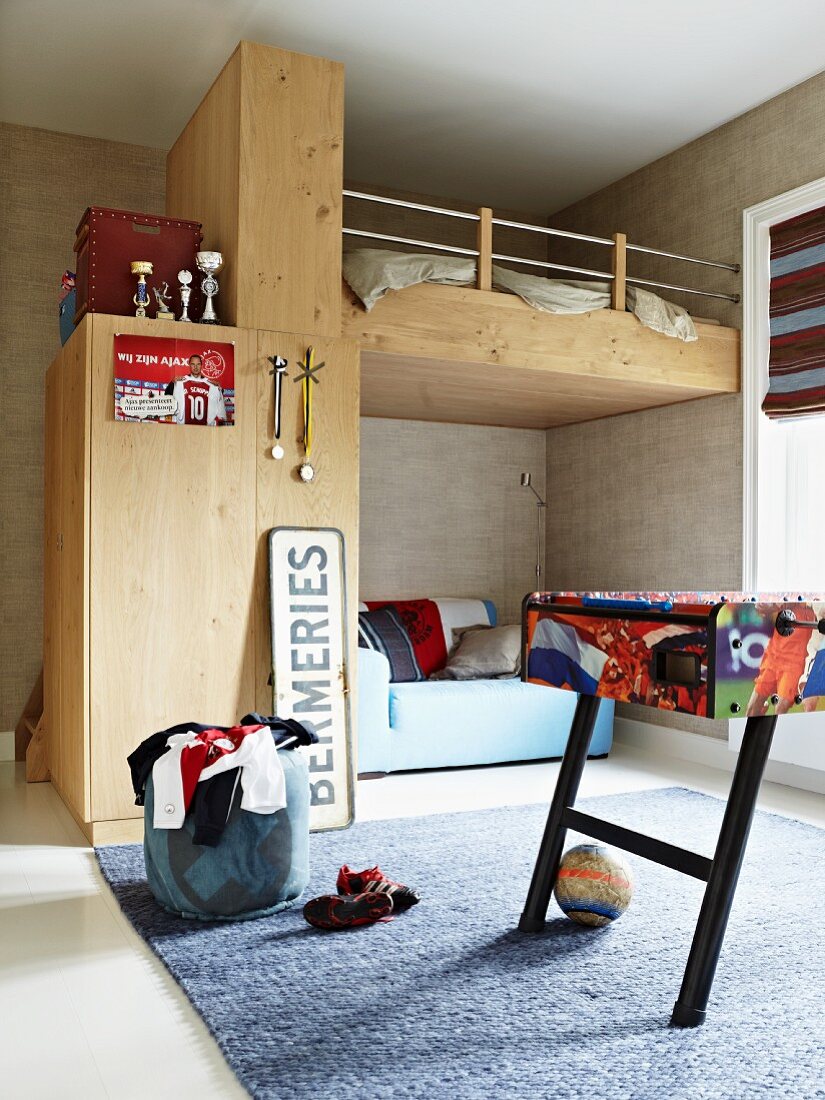 Custom loft bed in teenager's bedroom with table football table in foreground