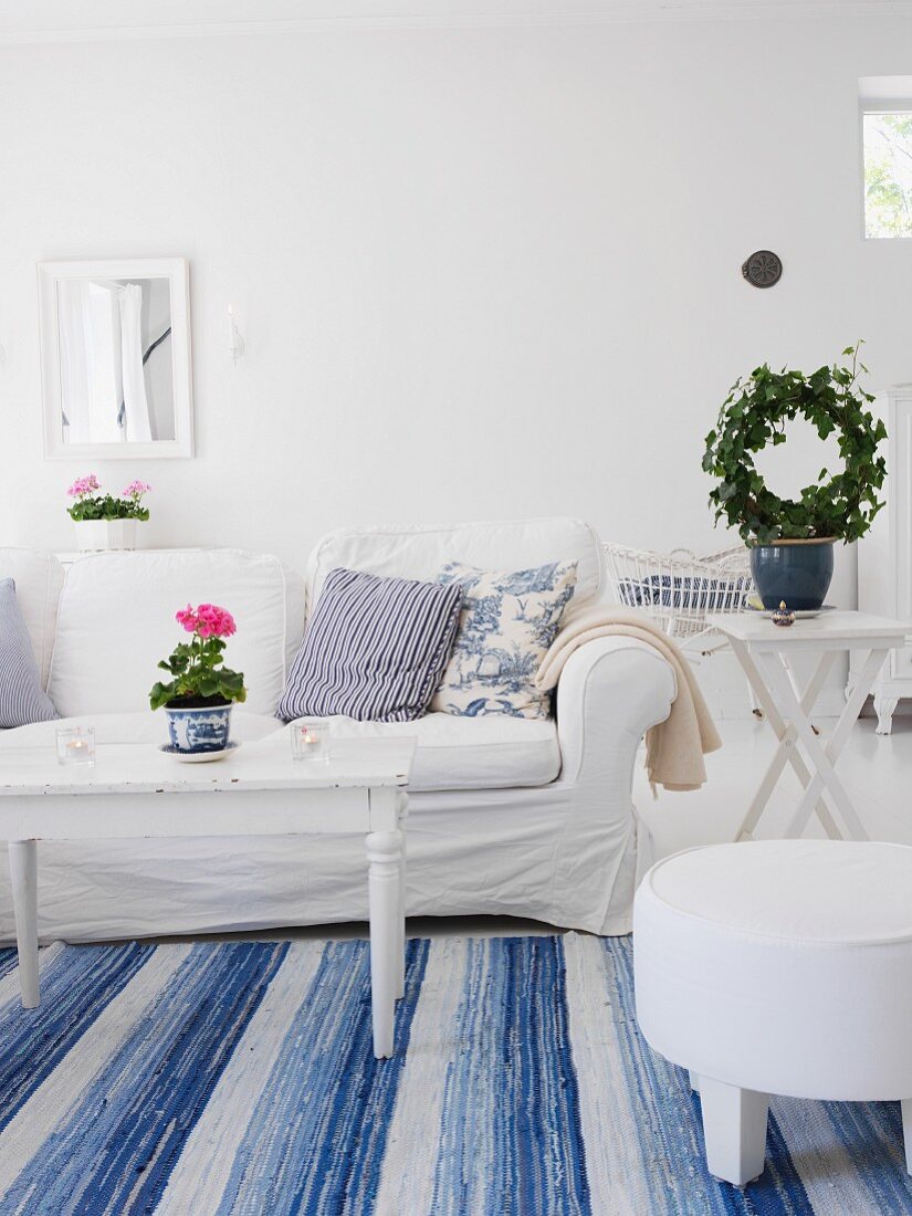 Swedish-style living room with white sofa & blue and white rug