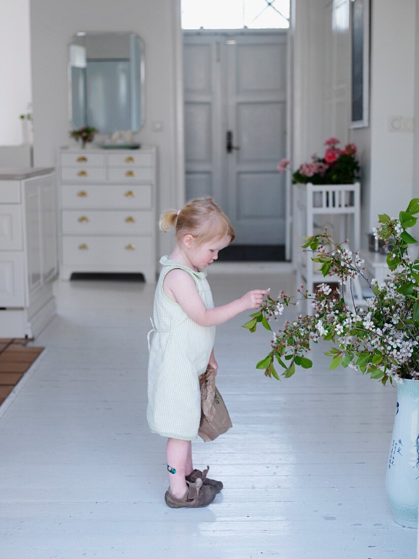 Little girl looking at bouquet in hallway