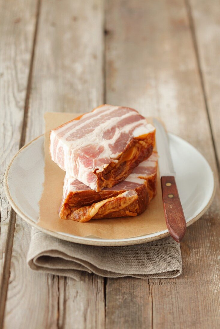 Smoked bacon on a plate with a knife