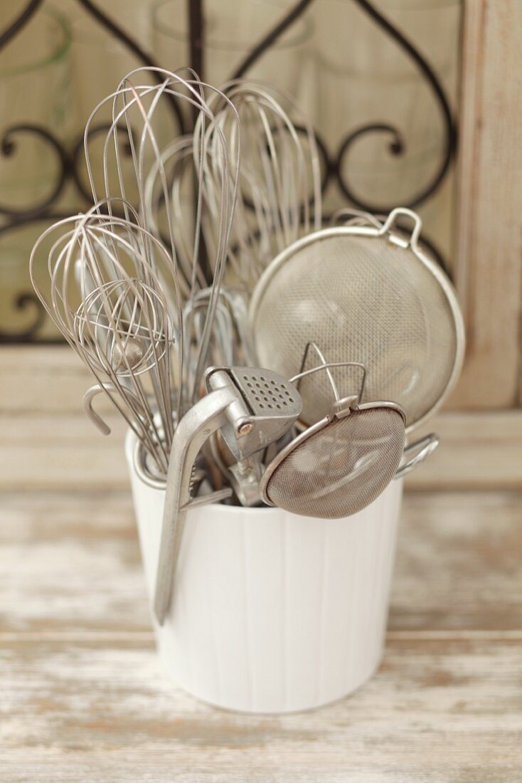 Assorted kitchen utensils in a ceramic pot