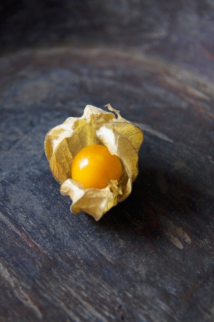 A Cape gooseberry on a wooden surface