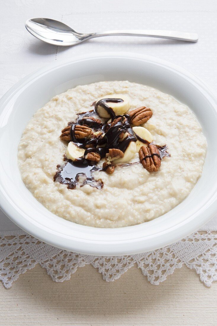 Porridge with chocolate sauce, bananas and pecans