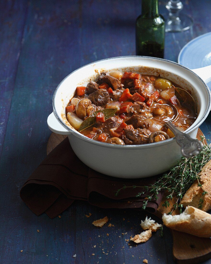 Beef daube in casserole dish with baguette