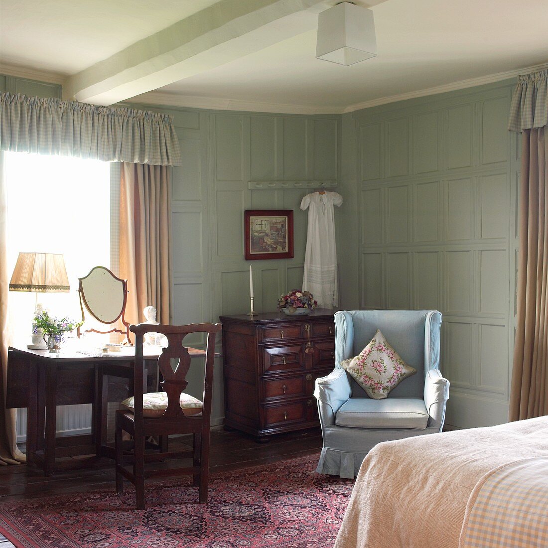 Old-fashioned bedroom with wingback chair and pastel blue wall panelling