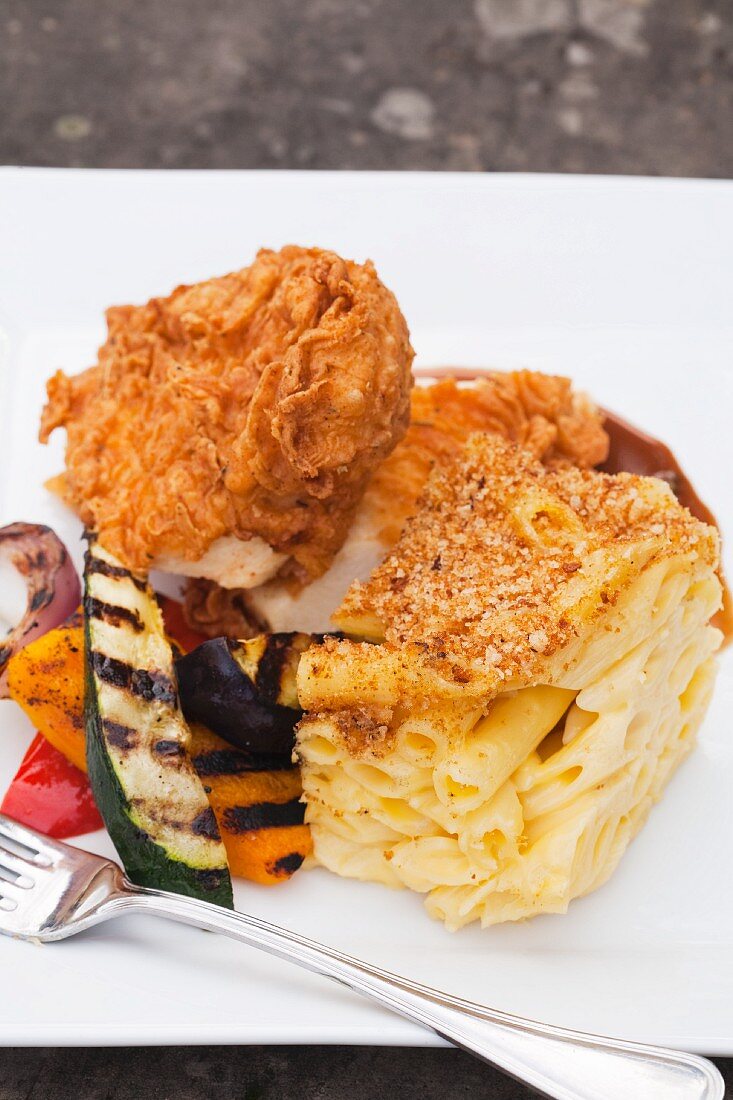 Fried Chicken with Grilled Vegetables and Baked Macaroni and Cheese on a White Plate