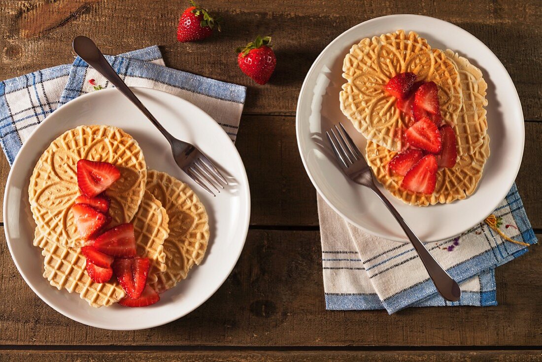 Two Plates of Pizzelles with Sliced Strawberries
