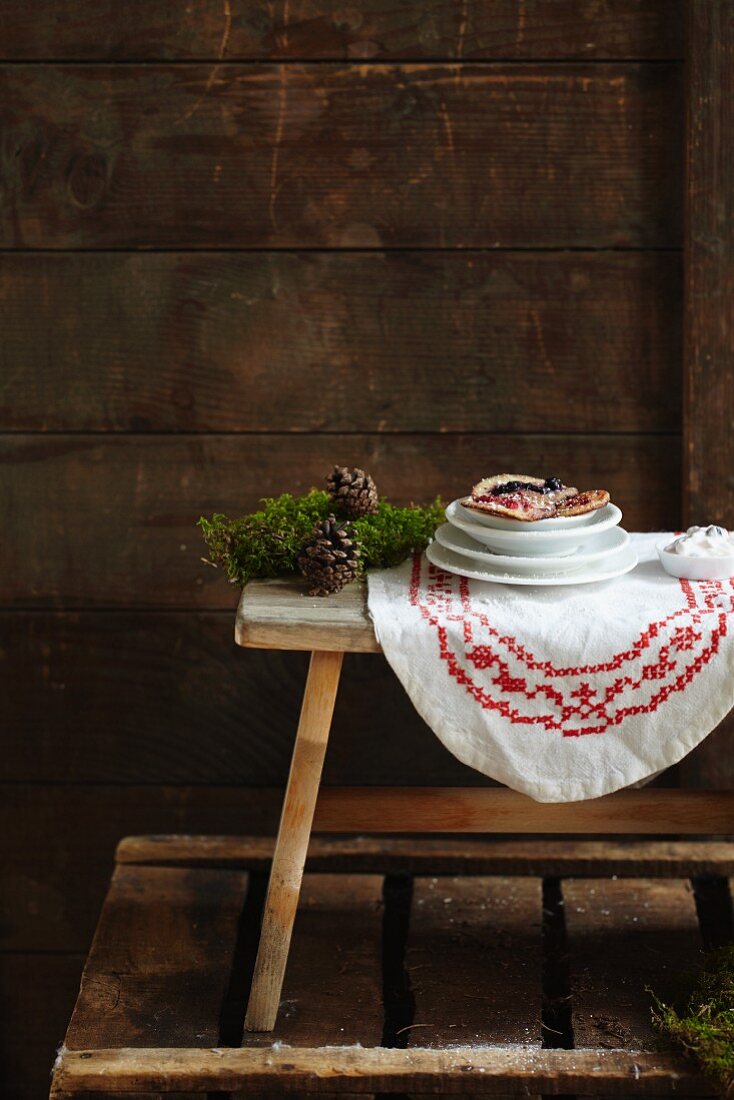 Kleine Pfannkuchen mit Beeren auf rustikalem Holztisch