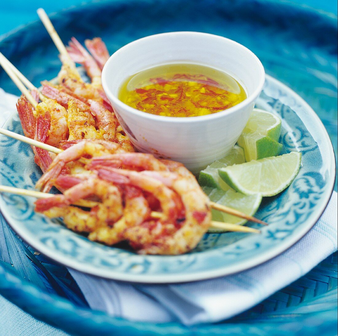 Prawn skewers with chilli sauce and limes