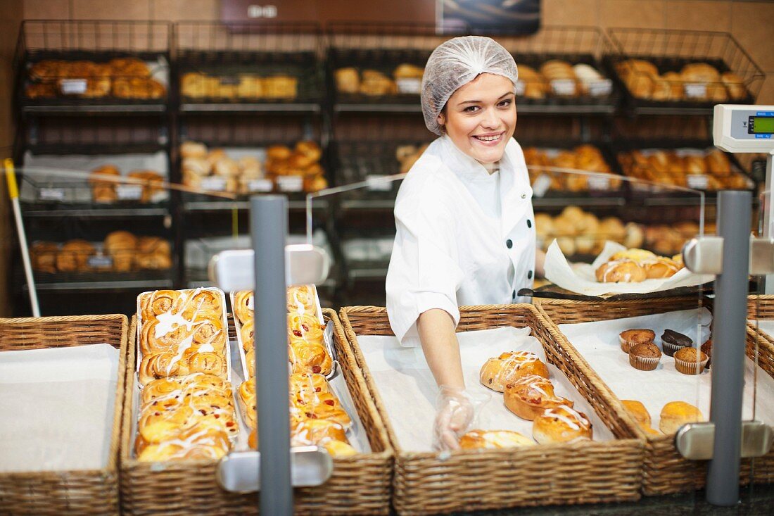 Young sales assistant holding sweet pastries