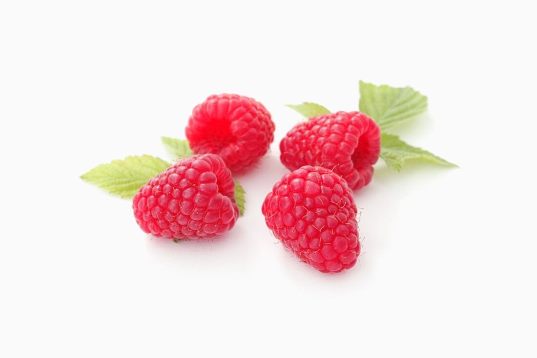 Vier Himbeeren mit Blättern