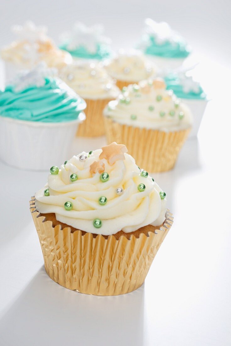 Cupcakes mit gelbem und grünem Frosting und Silberperlen verziert