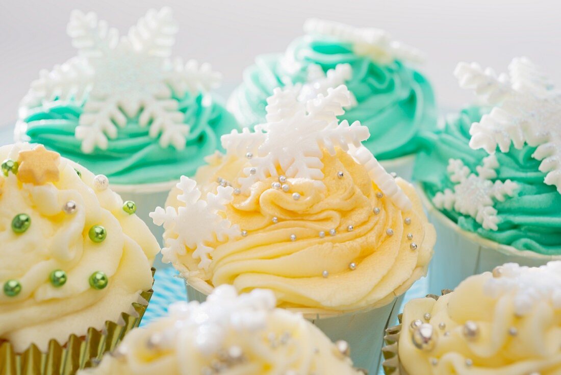Cupcakes decorated with a winter theme, with yellow and green icing