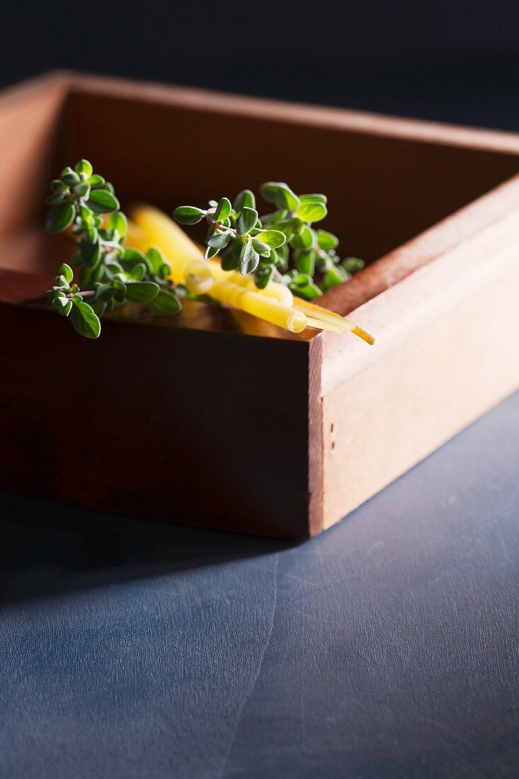 Pasta and fresh marjoram in a wooden box